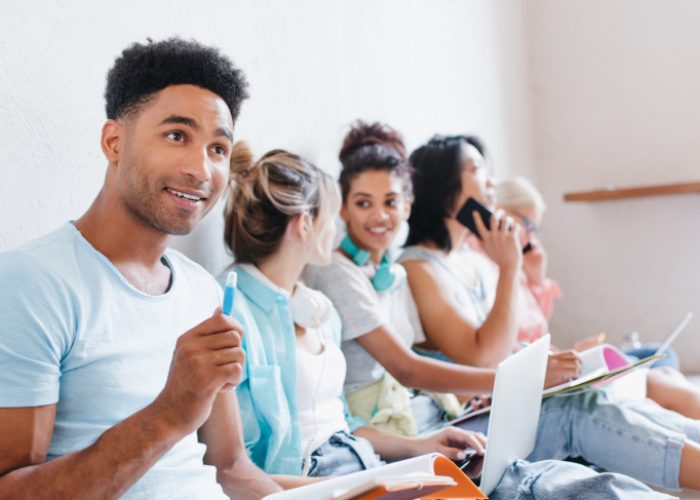 jovem-satisfeito-com-livros-e-livros-didaticos-olhando-para-cima-com-um-sorriso-enquanto-seus-colega.jpeg